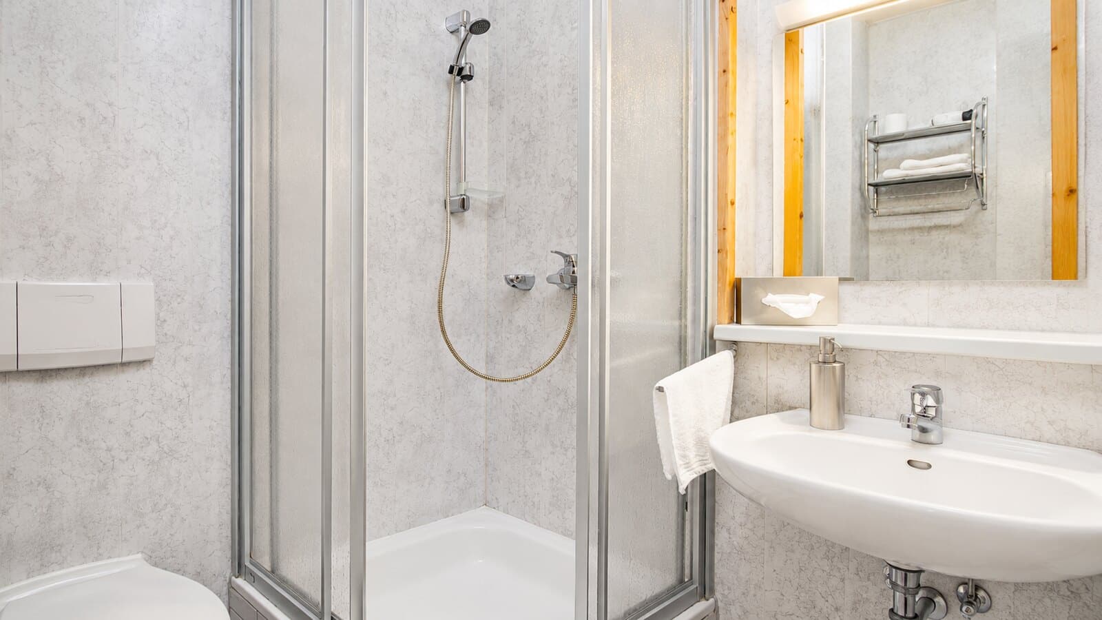 Helles Badezimmer mit Dusche und Waschbecken in der Pension Frankenthal