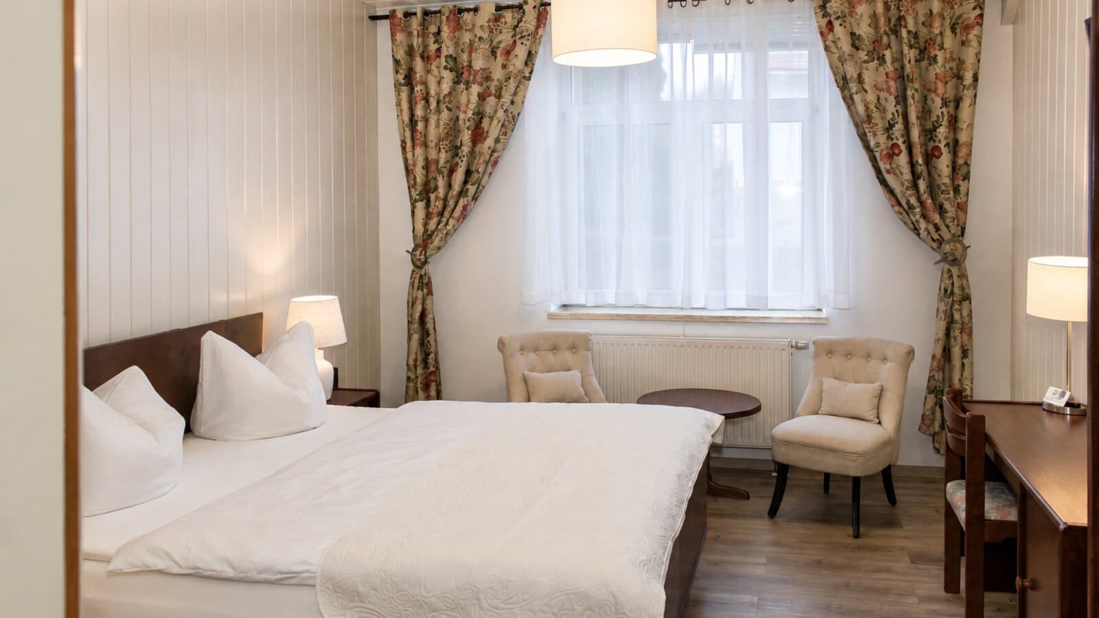 Helles Doppelzimmer mit Sitzecke in der Gasthof & Pension Frankenthal